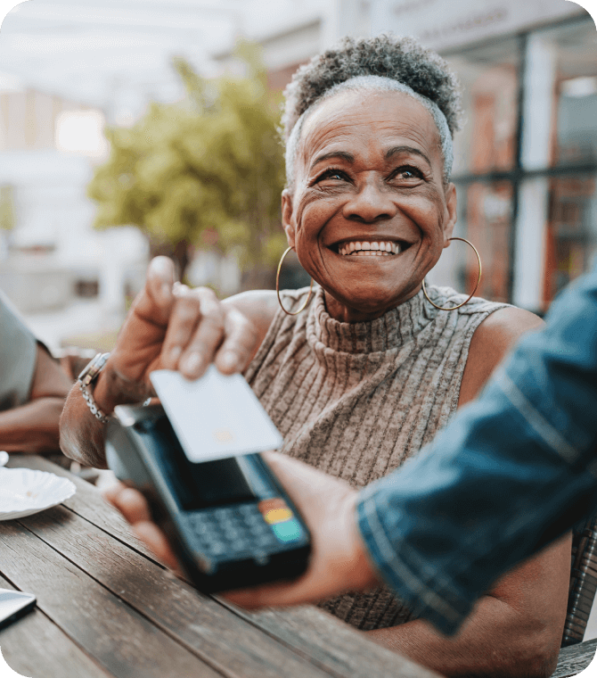 Woman making a contactless payment with a Guardian Credit Union debit card for secure spending