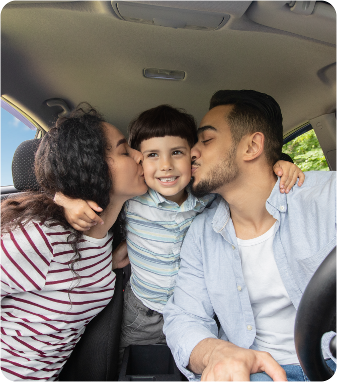 Parents kissing their son inside the car they purchased with a Guardian Credit Union loan and GAP coverage.