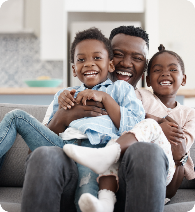 Happy father hugging his children in the living room after finding the best fit coverage solution with Guardian Insurance.