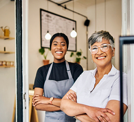Two women stand in their shop, representing Guardian CU’s business insurance coverage.