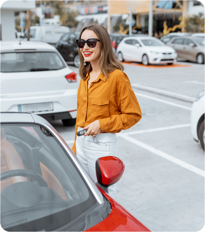 Buying a car with confidence—woman smiles by red car, highlighting Guardian Credit Union’s auto loan budget planning tools