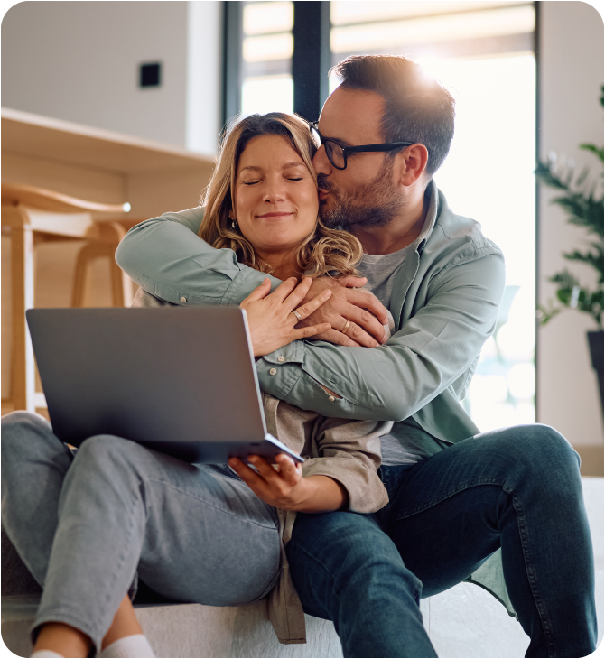 Happy couple sitting in their living room, confident their future is secure with Guardian Financial Planning.
