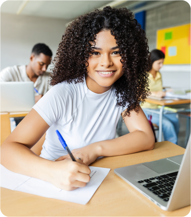 Student in classroom with laptop and notebook completing Guardian Credit Union Scholarship Program checklist.