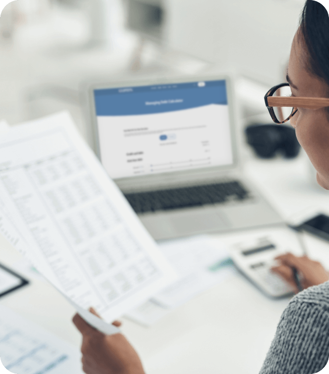 Woman reviewing financial reports and charts, using Guardian Credit Union services for budgeting