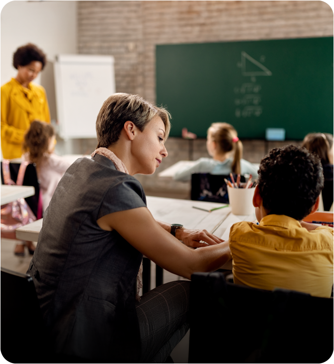 Young teacher assisting a student with a learning disability — reflecting the support The Guardian Foundation provides to the community.