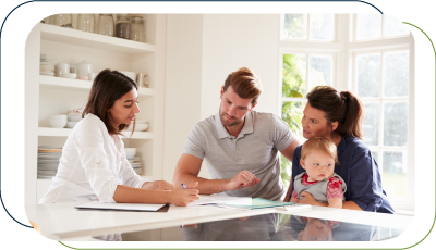 Couple holding a baby on lap while singning a home loan contract with the agent