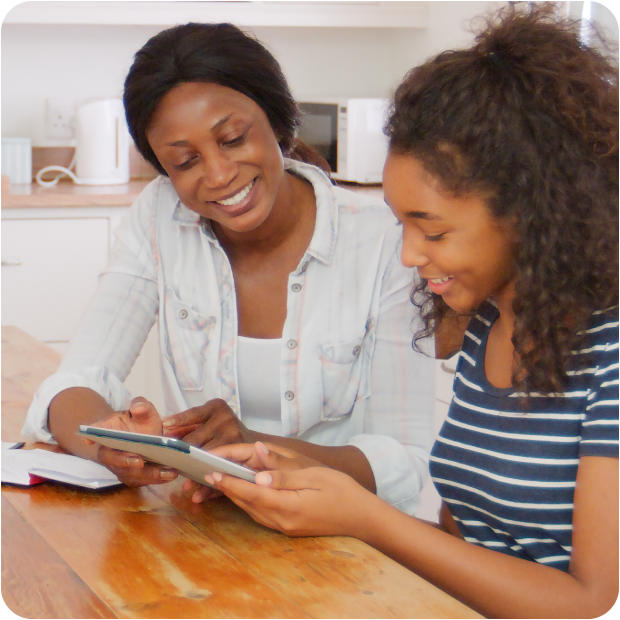 Parent and teen smile while opening a Guardian CU youth checking account online.